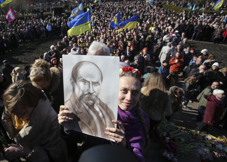 A woman holds a picture of Ukranian poet Taras Shevchenko at a rally in Kiev, Ukraine this afternoon.