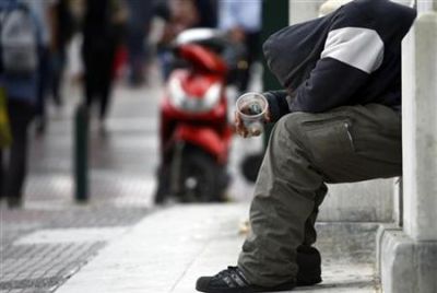 A beggar is seen on a street in central Athens
