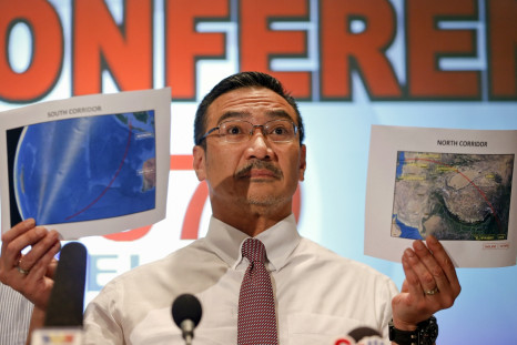 Malaysia's acting Transport Minister Hishammuddin Hussein shows two maps with corridors of the last known possible location of the missing Malaysia Airlines MH370