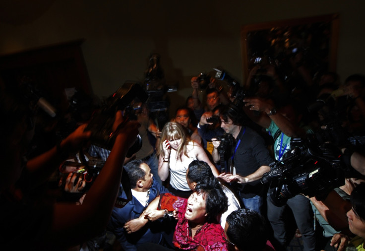 A Chinese family member of a passenger onboard the missing Malaysia Airlines Flight MH370 screams as she is being brought into a room outside the media conference area at a hotel in Kuala Lumpur International Airport