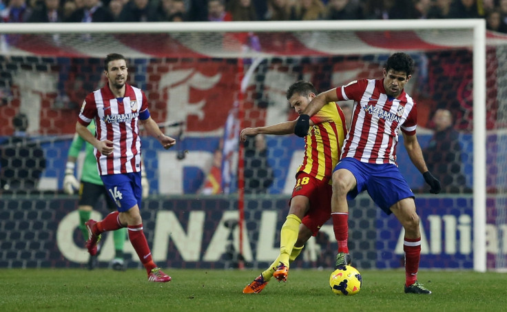 Barcelona's Jordi Alba (C) fights for the ball with Atletico Madrid's Diego Costa (R) during their Spanish first division soccer match at the Vicente Calderon stadium in Madrid January 11, 2014.