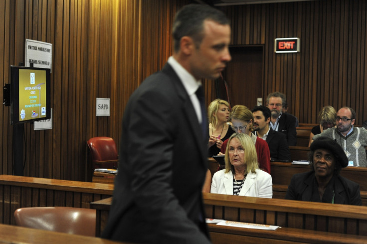 June Steenkamp (in white) watches Oscar Pistorius walk to the dock at his trial for killing Reeva Steenkamp