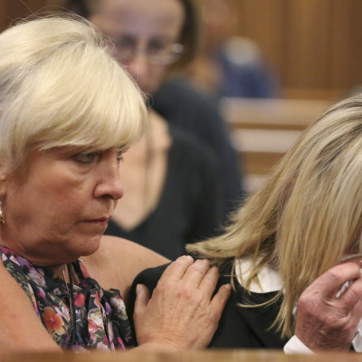 June Steenkamp (in black) is comforted by a friend while hearing about private text messages between daughter Reeva and Oscar Pistorius