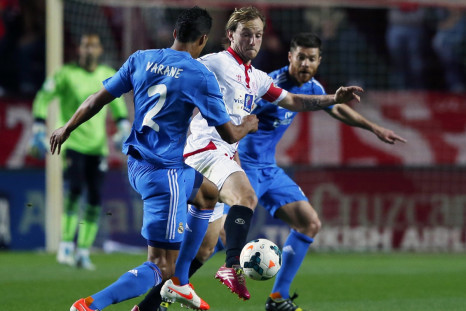 Sevilla's Ivan Rakitic (C) is challenged by Real Madrid's Xabi Alonso (R) and Raphael Varane during their Spanish First Division soccer match at Ramon Sanchez Pizjuan stadium in Seville, March 26, 2014.