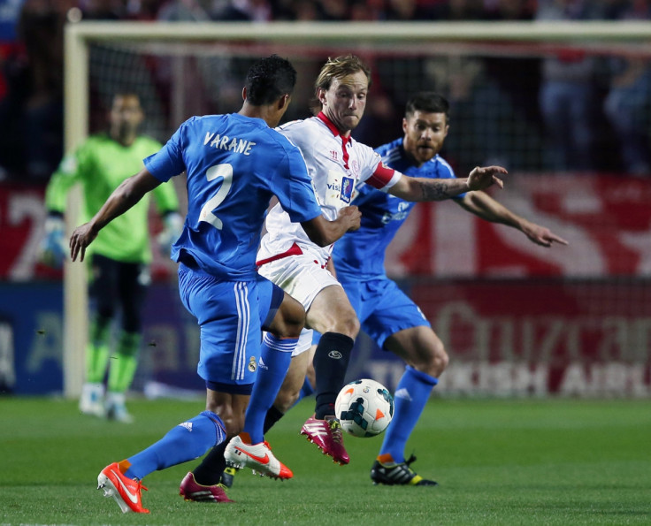 Sevilla's Ivan Rakitic (C) is challenged by Real Madrid's Xabi Alonso (R) and Raphael Varane during their Spanish First Division soccer match at Ramon Sanchez Pizjuan stadium in Seville, March 26, 2014.