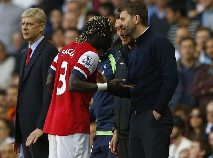 Arsenal's Bacary Sagna (L) reacts after he was hit by a ball thrown by Tottenham Hotspur's manager Tim Sherwood (R) during their English Premier League soccer match at White Hart Lane in London, March 16, 2014.
