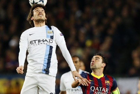 Manchester City's David Silva (L) heads the ball next to Barcelona's Xavi during their Champions League last 16 second leg soccer match at Camp Nou stadium in Barcelona March 12, 2014.