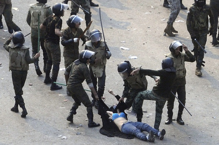 Egyptian army soldiers violently arrest a female protester during clashes in Tahiri Square in Cairo.