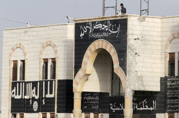 A rebel fighter stands atop a former base used by fighters from the Islamic State in Iraq and al-Shah after rebel fighters recaptured it in al-Dana town in Idlib province