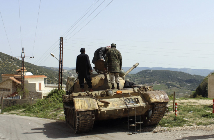 Free Syrian Army fighters stand on a tank at the Armenian Christian town of Kasab