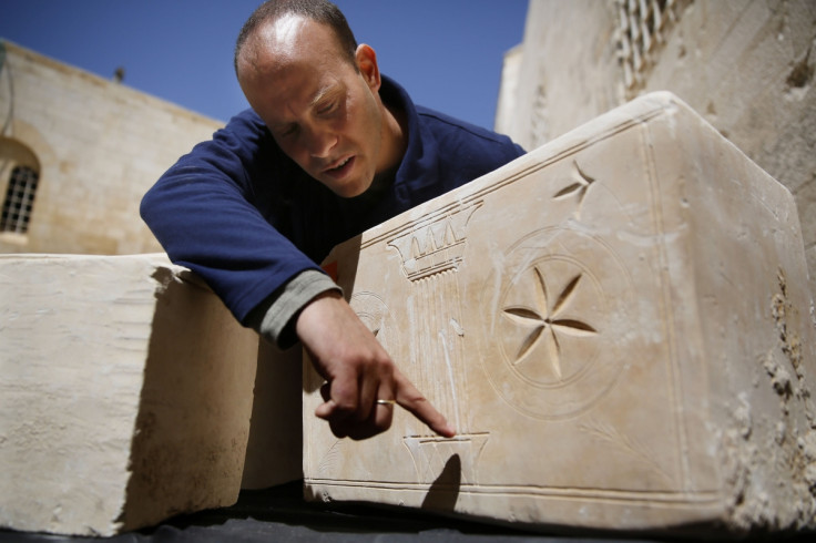 Israeli archeologist Eitan Klein of the Antiquities Theft Prevention Unit points at an engraved detail on one of the 11 ancient coffins containing Jewish bones from the Second Temple period