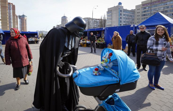 "Darth Vader", the leader of the Internet Party of Ukraine, looks at a child in a pram at a street market near the Ukrainian Central Elections Commission in Kiev