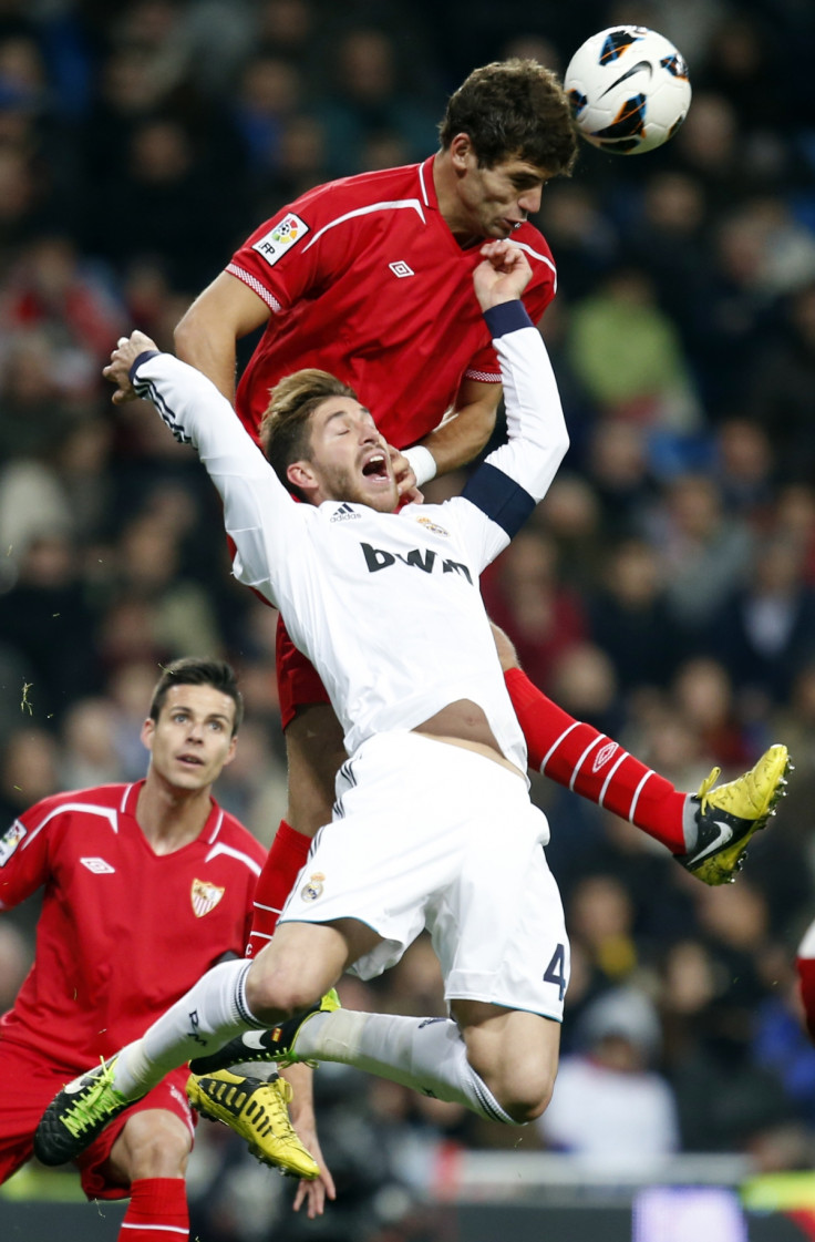 Real Madrid's Sergio Ramos (bottom) and Sevilla's Federico Fazio challenge for the ball during their Spanish first division soccer match at Santiago Bernabeu stadium in Madrid February 9, 2013.