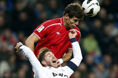Real Madrid's Sergio Ramos (bottom) and Sevilla's Federico Fazio challenge for the ball during their Spanish first division soccer match at Santiago Bernabeu stadium in Madrid February 9, 2013.