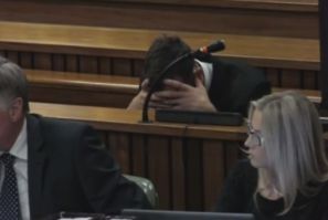 Oscar Pistorius holds his head in his hands as his trial resumes for killing Reeva Steenkamp