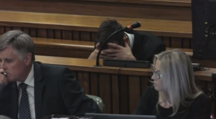 Oscar Pistorius holds his head in his hands as his trial resumes for killing Reeva Steenkamp
