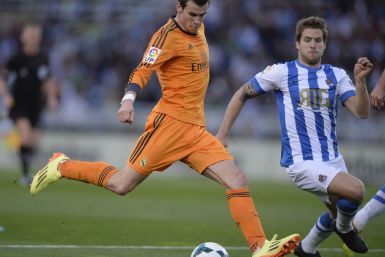 Real Madrid's Gareth Bale (L) shoots the ball past Real Sociedad's Inigo Martinez during their La Liga soccer match at Anoeta stadium in San Sebastian April 5, 2014.