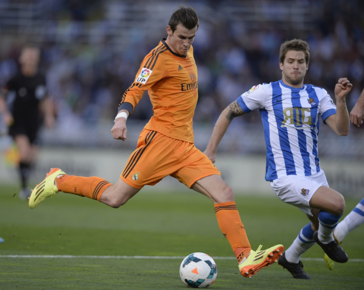 Real Madrid's Gareth Bale (L) shoots the ball past Real Sociedad's Inigo Martinez during their La Liga soccer match at Anoeta stadium in San Sebastian April 5, 2014.