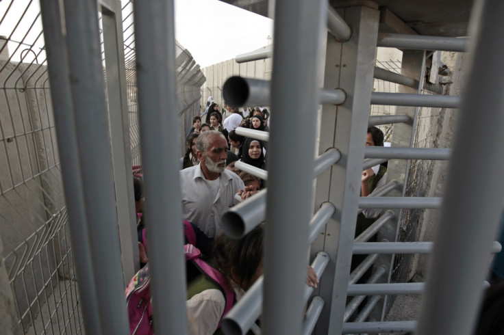 Palestinians wait to cross through an Israeli checkpoint as they enter Shuafat refugee camp in the West Bank near Jerusalem