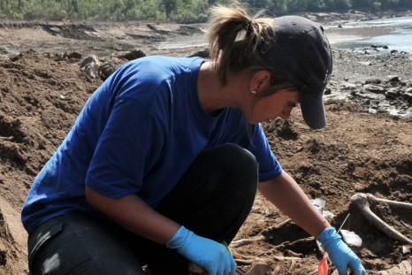 forensic expert from the International Commission On Missing Persons uncovers human remains near the eastern Bosnian town of Visegrad