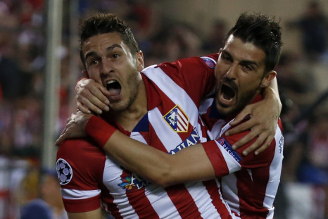 Atletico Madrid's Jorge "Koke" Resurreccion Merodio (L) and David Villa celebrate their team's first goal against Barcelona during their Champions League quarter-final second leg soccer match in Madrid, April 9, 2014.