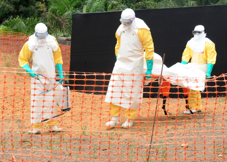 Caption:Staff of the 'Doctors without Borders' ('Medecin sans frontieres') medical aid organisation carry the body of a person killed by Ebola, at a center for victims of the Ebola virus in Guekedou, Guinea.