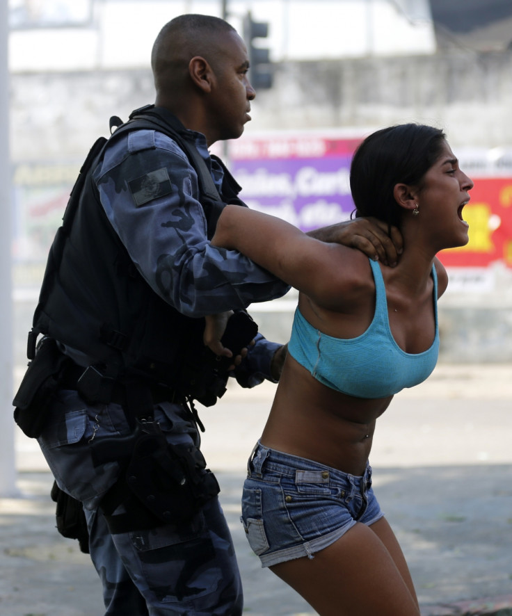 A riot policeman arrests a demonstrator from a favela in Rio de Janeiro