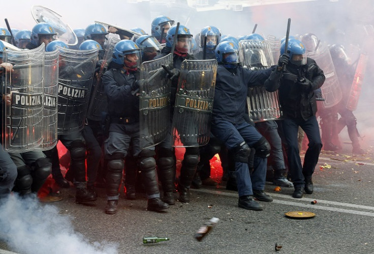 Riot police face off with protesters throwing bottles and flares during an anti-austerity protest in Rome.