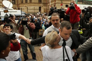 Oscar Pistorius embraced by blonde woman as he arrives at his murder trial