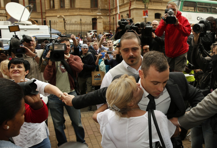 Oscar Pistorius embraced by blonde woman as he arrives at his murder trial