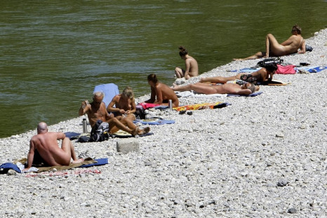 People sunbathe next to the Isar river in downtown Munich.
