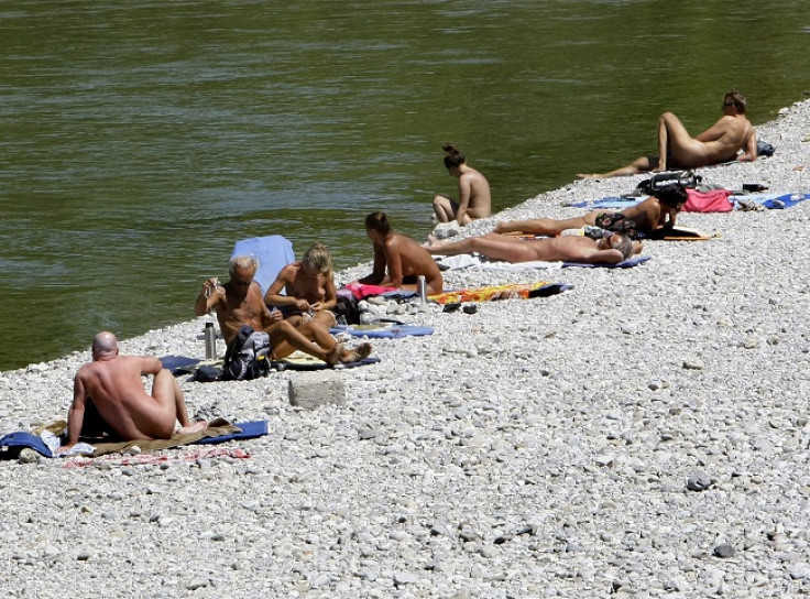 People sunbathe next to the Isar river in downtown Munich.