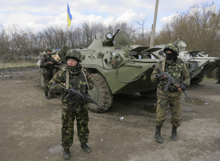 Ukrainian soldiers are seen near armored personnel carriers at a checkpoint near the town of Izium in Eastern Ukraine