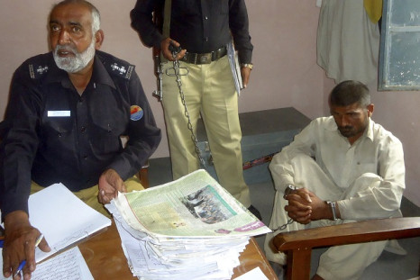 Mohammad Arif, 35, (R) sits in a police custody at a police station, in the town of Darya Khan in Bhakkar District