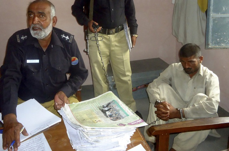 Mohammad Arif, 35, (R) sits in a police custody at a police station, in the town of Darya Khan in Bhakkar District