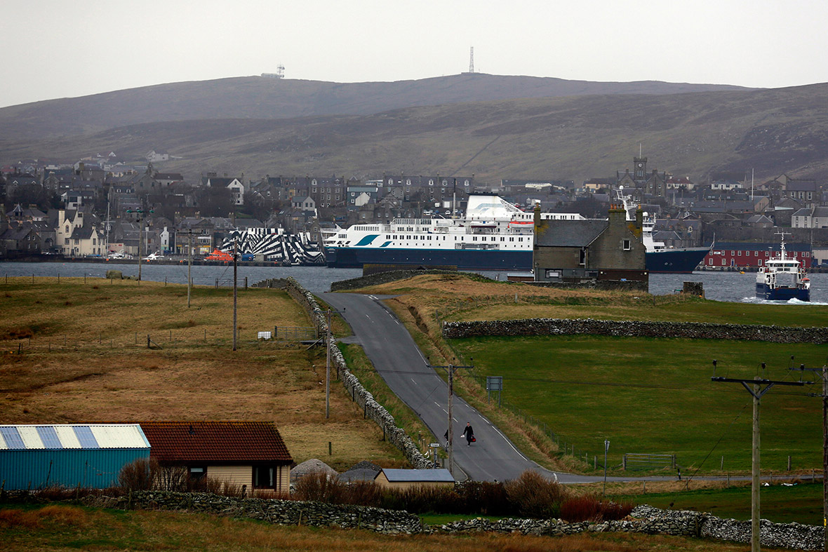 Boys walk up a road on the small island of Bressay after taking the ferry across from Lerwick in the distance