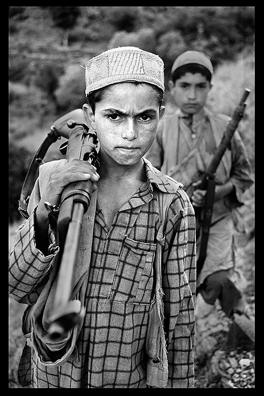 A young boy stands with his firearm, 1979