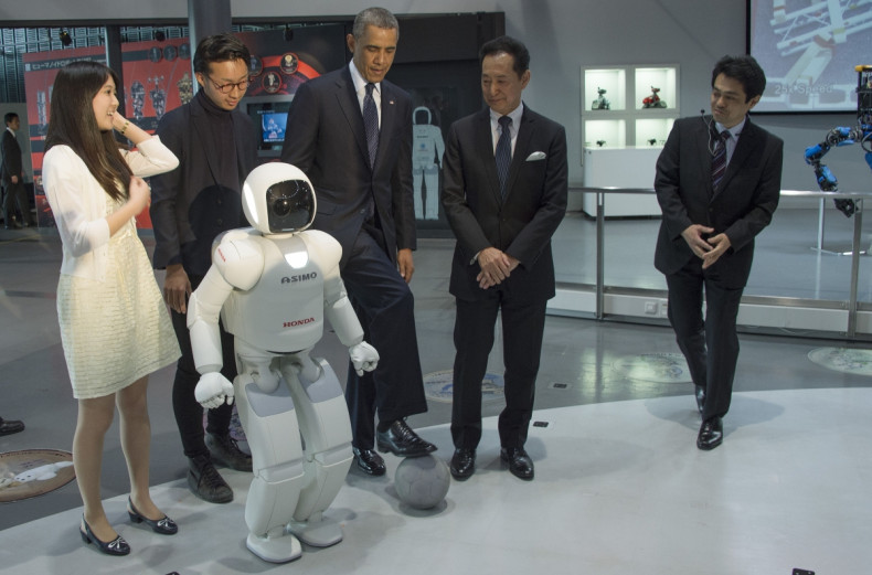 President Barack Obama plays football with Honda's humanoid robot ASIMO on a state visit to Japan