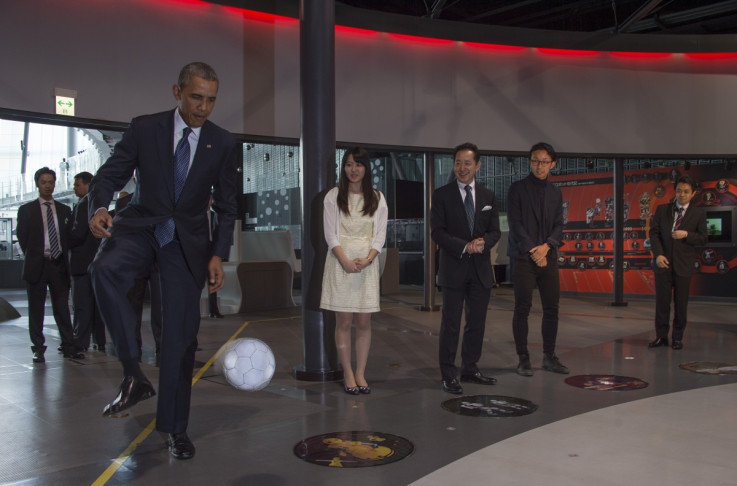 President Obama deftly stops and kicks the football back to the Honda robot ASIMO