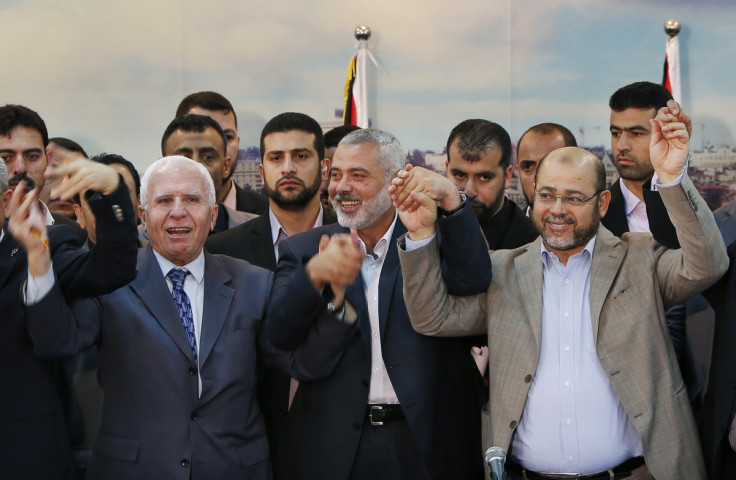 Senior Fatah official Azzam Al-Ahmed (L), head of the Hamas government Ismail Haniyeh (C) and senior Hamas leader Moussa Abu Marzouq hold their hands after announcing a reconciliation agreement in Gaza City