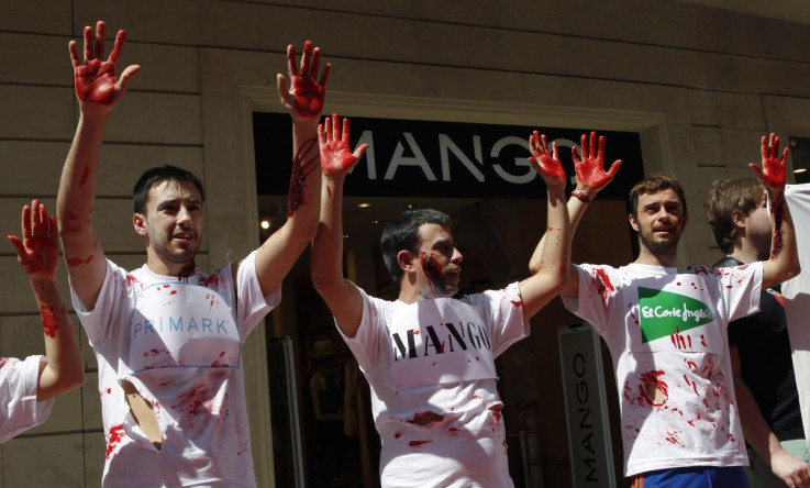 Activists from Spanish trade union UGT (General Union of Workers) hold up hands covered in fake blood as they take part in a protest in front of a Mango store in central Barcelona May 7, 2013.