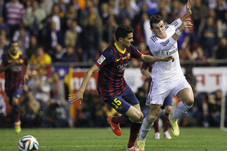Barcelona's Marc Bartra (L) battles for the ball against Real Madrid's Gareth Bale before Bale scored his goal during their King's Cup final soccer match at Mestalla stadium in Valencia April 16, 2014.