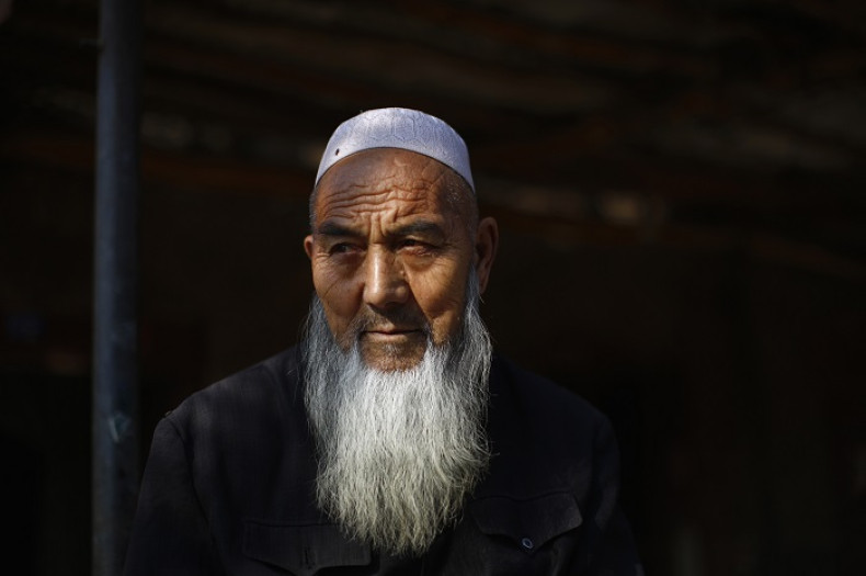 An ethnic Uighur man sits outside his house near a busy market in Turpan, Xinjiang province.