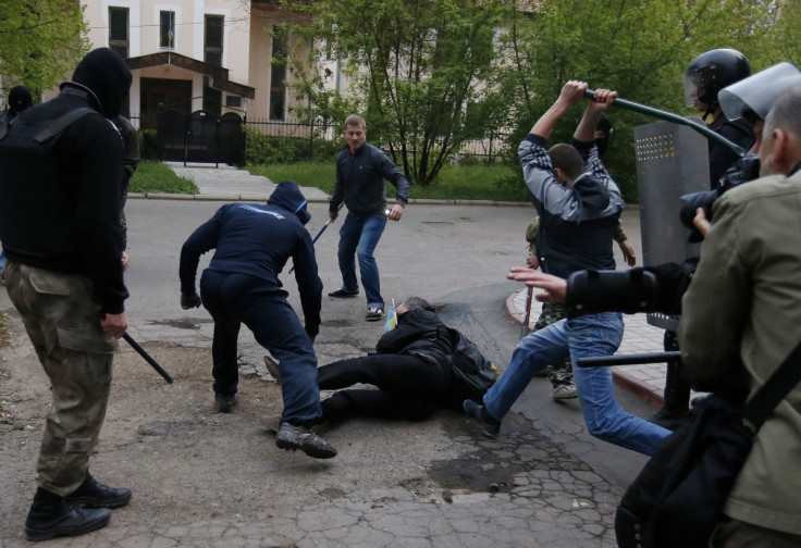 EU Slaps Sanctions on 15 Russian Politicians, Separatist Leaders and Military Chiefs: pro-Russian protesters attack a pro-Ukranian protester during a pro-Ukraine rally in the eastern city of Donetsk April 28, 2014.