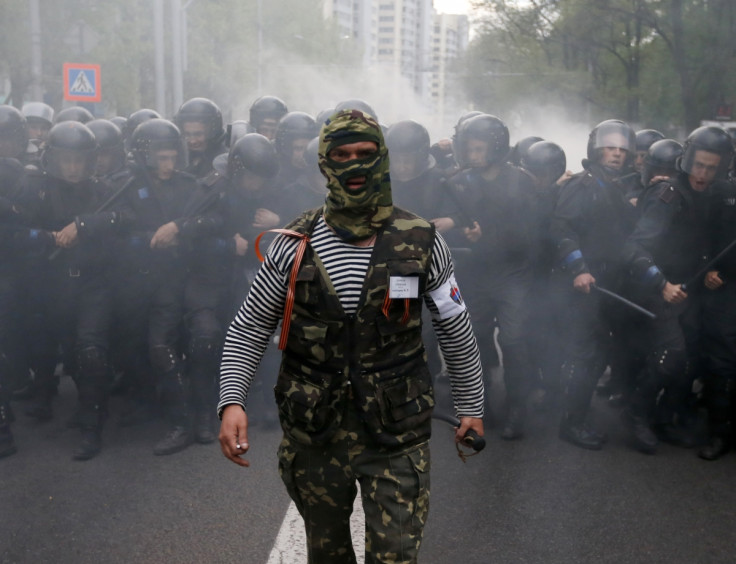 A pro-Russian activist walks in front of Ukrainian riot police during a pro-Ukrainian rally in the eastern city of Donetsk April 28