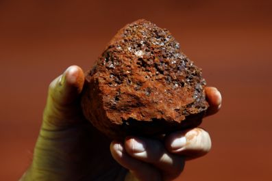 A miner holds a lump of iron ore