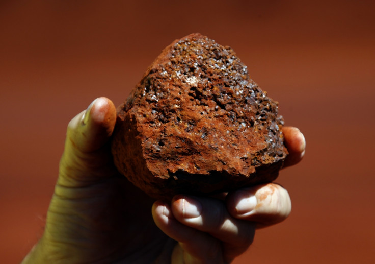 A miner holds a lump of iron ore