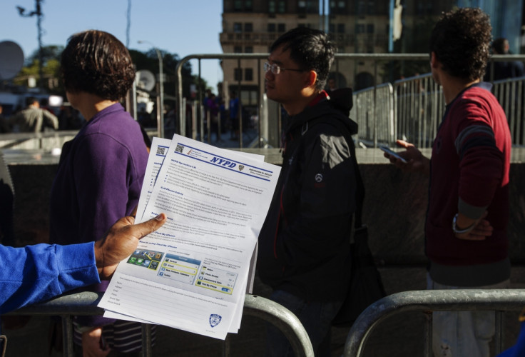 Police in new york hand out information warning against smartphone theft to customers queuing at the Apple store for the release of a new iPhone device.