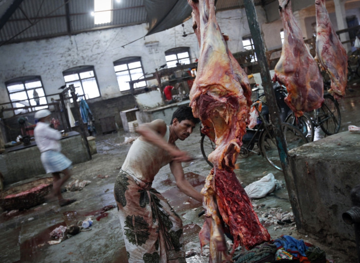 A butcher cuts up portions of beef for sale in an abattoir at a wholesale market in Mumbai