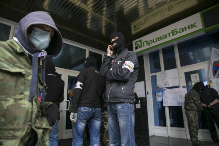 Masked pro-Russian activists stand outside a branch of Ukraine's Privatbank during a protest in Donetsk, eastern Ukraine